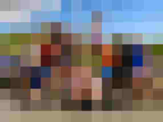 Junge Gruppe posiert fröhlich vor Quads bei sonniger Quad Tour Mallorca für Gruppenevent